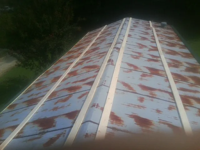 Rusted metal roof panels with new wood purlins before replacement — Storm Damage Roof Repair in Tariffville by Roofing Brothers