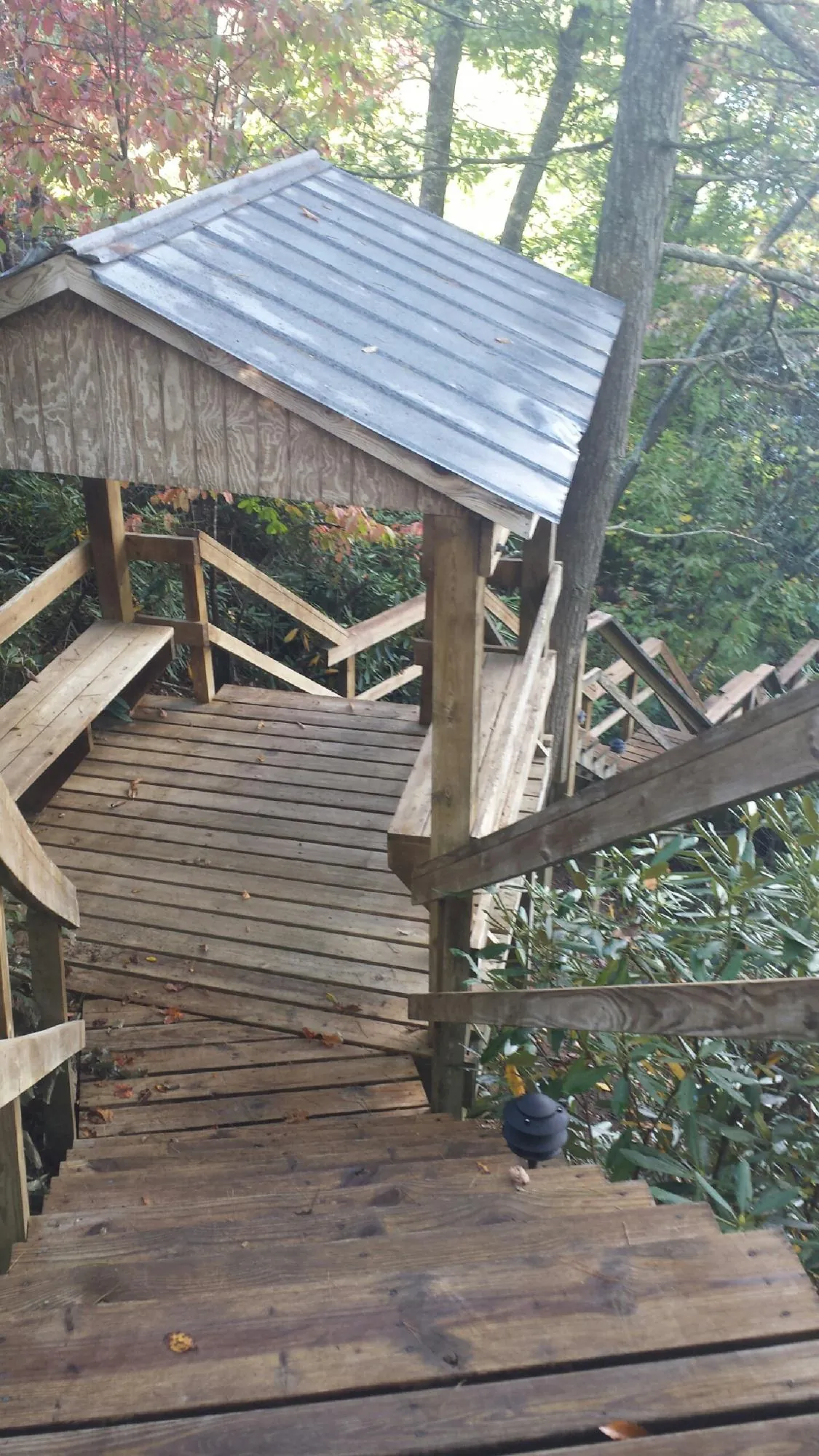 Metal roofed shelter over wooden steps on a wooded walkway — Skylight Repair & Installation work by our crew in Tariffville